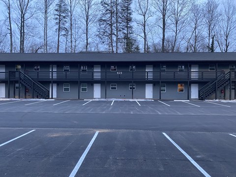an empty parking lot with a building in the background