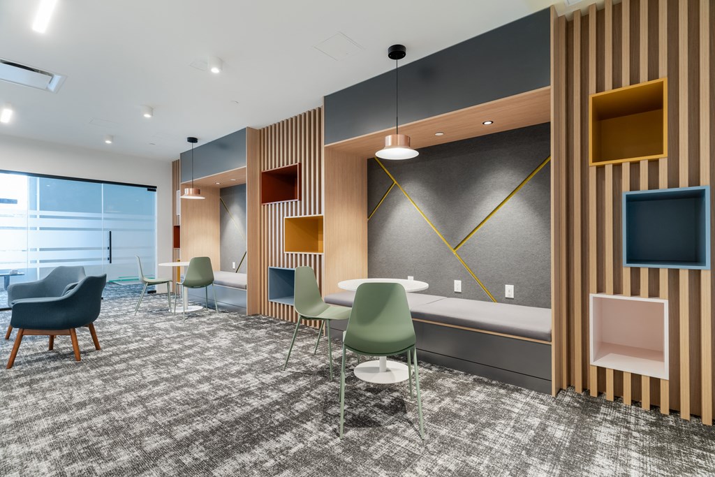 a lounge area with chairs and a table and a bed