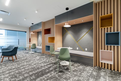 A room with a grey carpet and wooden paneling.