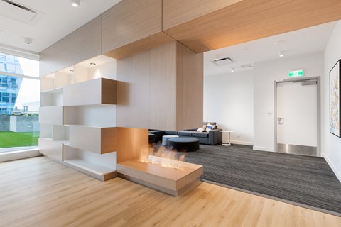 A modern living room with a black couch and a wooden coffee table.