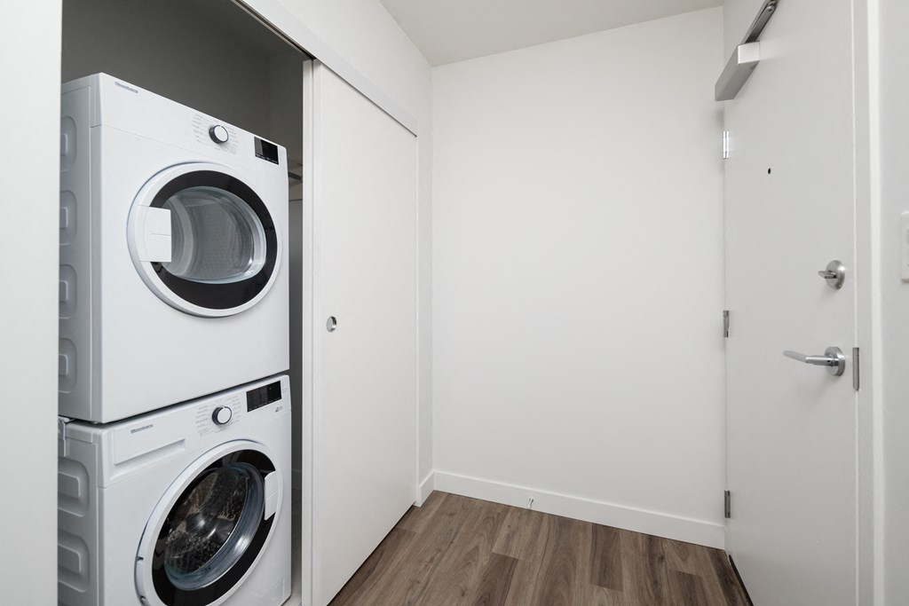 a front loading washer and dryer in a room with a door