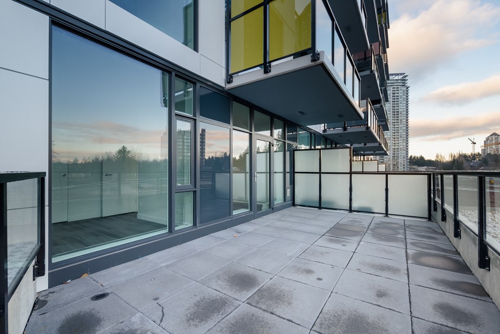 a balcony with glass doors and a view of the city