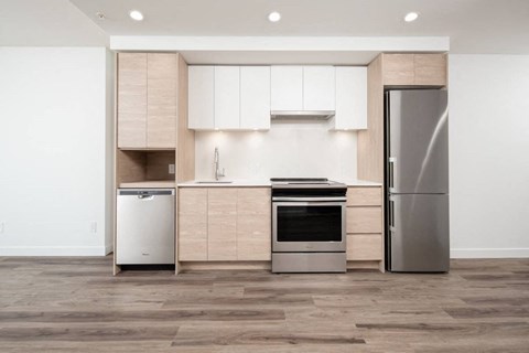A modern kitchen with a refrigerator, dishwasher, and oven.