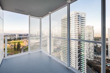 A room with a view of a cityscape through large windows.