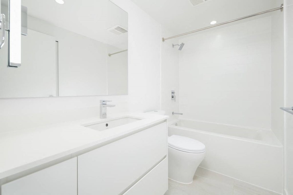 a white bathroom with a toilet and a sink