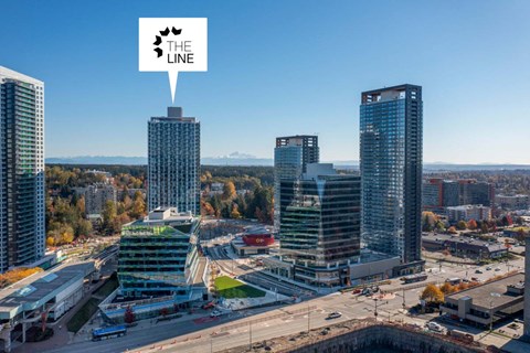 A cityscape with a clear sky and a logo in the top left corner.