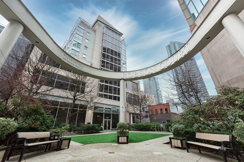 A modern building with a glass facade and a circular walkway in front.