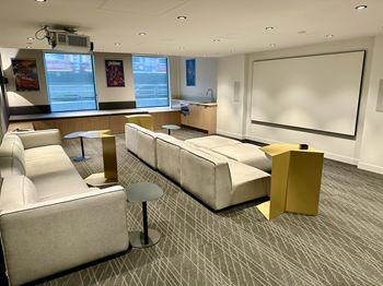 A conference room with a white screen and a long table.