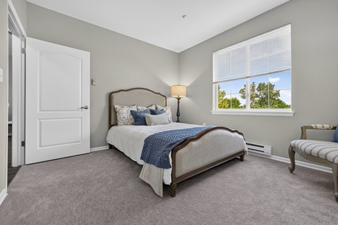 Bedroom with upholstered bed and natural light at Lakeview Senior Living Apartments, Colorado, 80227
