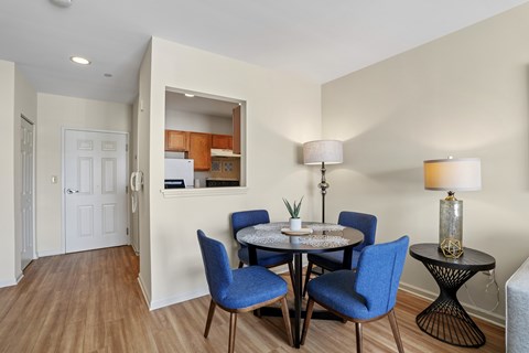 A dining room with a round table and blue chairs.