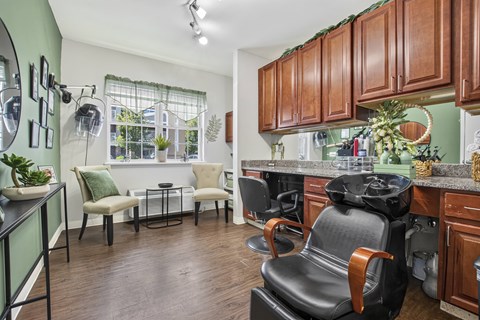 A kitchen with brown cabinets and a black chair.