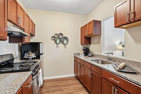 A kitchen with brown cabinets and a black stove top oven.