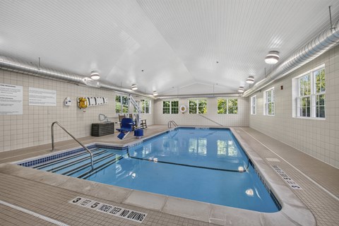 Indoor swimming pool with entry stairs and seating area at Glenmont Abbey Village Apartments, Glenmont, NY