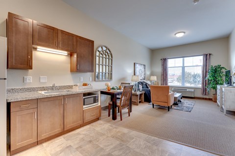 A kitchen with wooden cabinets and a dining table with chairs.