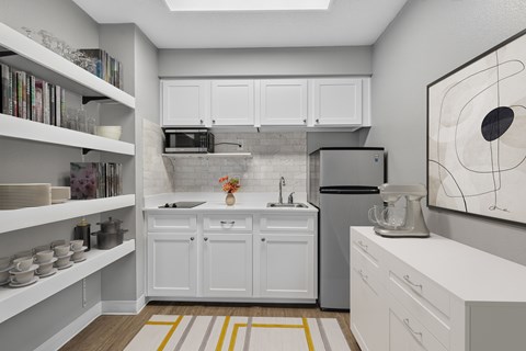 A kitchen with white cabinets and a grey backsplash.