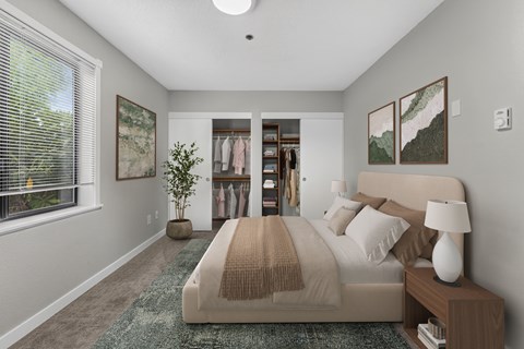 A bedroom with a large bed and a window with blinds.