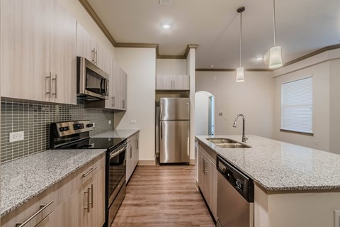A kitchen with a refrigerator in the middle of the room.