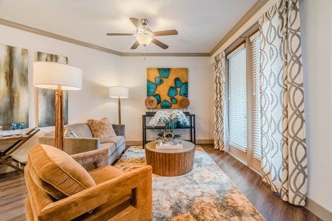 A living room with a brown chair and a painting on the wall.