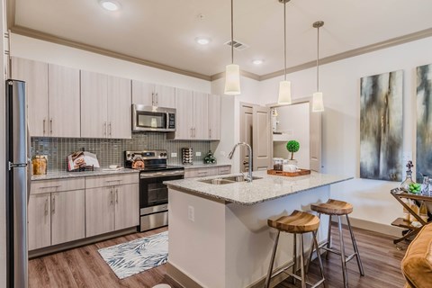 A kitchen with a white countertop and wooden floors.
