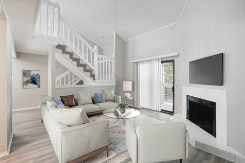 A living room with a white couch and a fireplace.