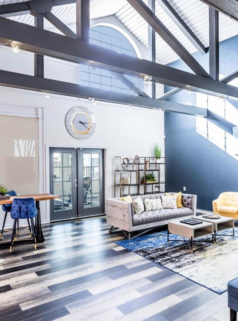 A living room with a grey couch and a wooden table.