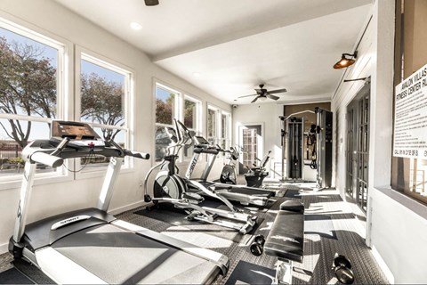 A gym with treadmills, exercise bikes, and weights. at Avalon Villas Apartments , Irving, TX, 75062