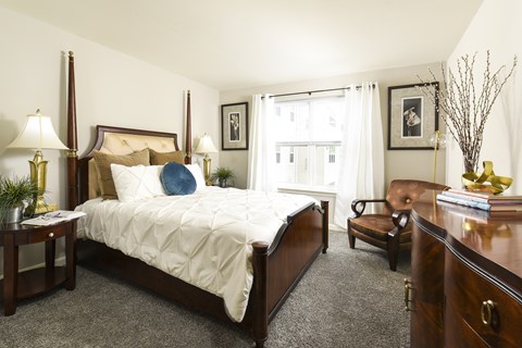 Traditional bedroom with four poster bed and wood furniture at Chestnut Oaks Apartments, Fort Washington