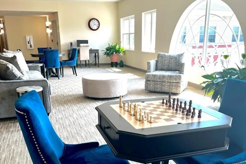 A chess board is set up on a table in a living room.