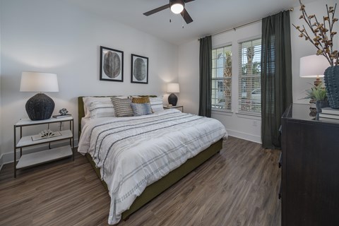 A bedroom with a bed, nightstand, and a ceiling fan. at Atwater at Nocatee Apartments, Florida