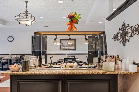 A kitchen with a counter and a clock on the wall.