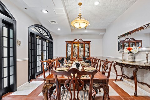A dining room with a large table set for a meal.