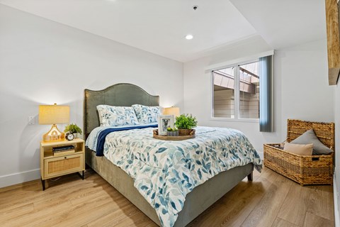 A bedroom with a large bed and a basket on the floor.