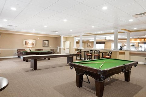A room with a pool table and a billiard table.