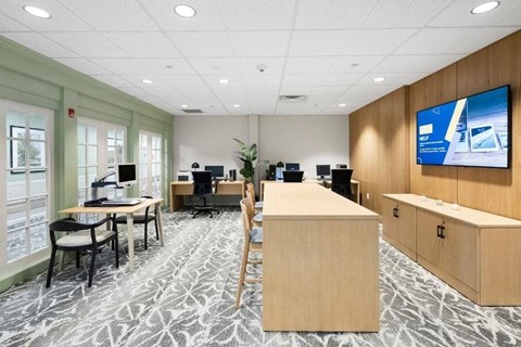 A modern office space with a large screen TV mounted on the wall.