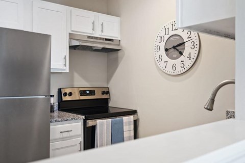 A kitchen with a clock on the wall.