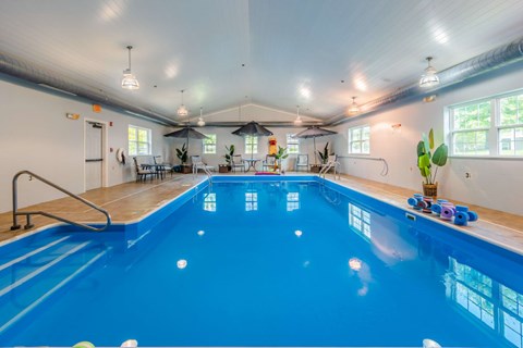 Indoor swimming pool with seating area at Schuyler Commons Apartments, Utica, New York