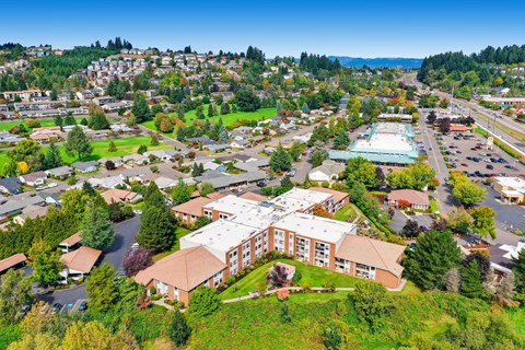 Aerial view of multistory residential buildings with green lawns at King City Senior Village Apartments, King City