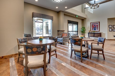 A dining room with a table surrounded by chairs.