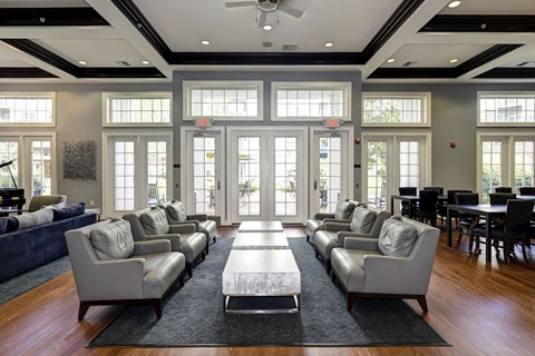 A spacious living room with a long couch and a rug in the middle.