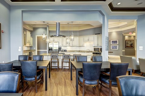 A kitchen with a table and chairs in front of it.