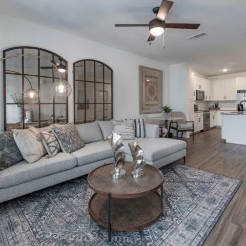 A modern living room with a grey sofa and a wooden coffee table.
