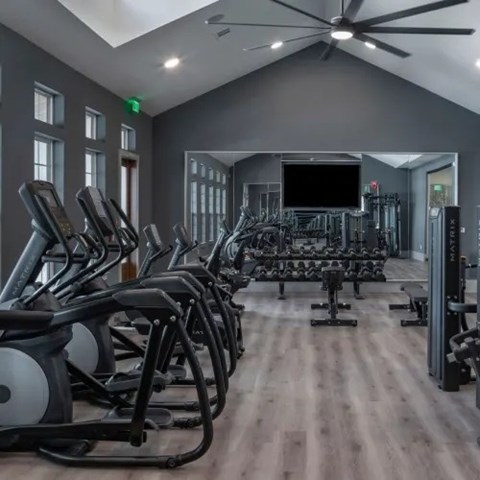 A gym with treadmills, elliptical machines, and a television. at Atwater at Nocatee Apartments, Toledo, FL
