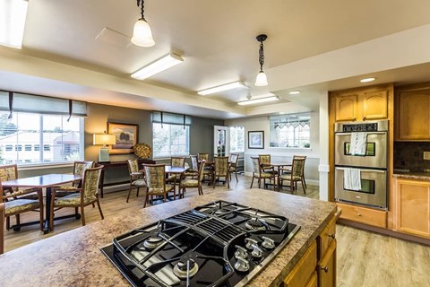 A kitchen with a black stove top oven and wooden cabinets.