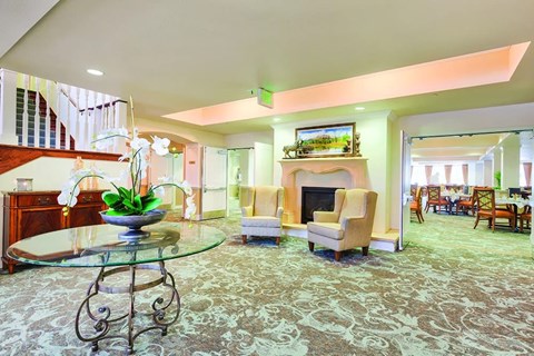 A living room with a fireplace and a glass table.
