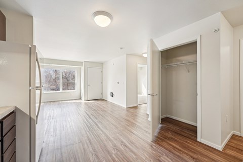 A spacious room with wooden floors and white walls.
