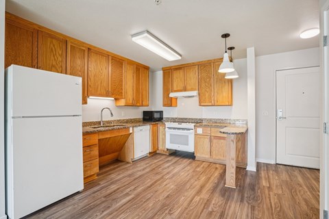 A kitchen with wooden cabinets and a white refrigerator.