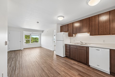 A kitchen with white appliances and wooden cabinets.