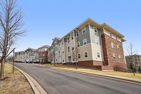 A street view of a residential area with apartment buildings on the side.