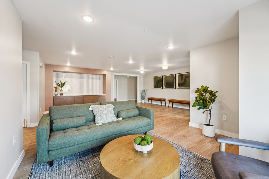 A living room with a green couch and a wooden coffee table.