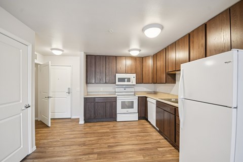 A kitchen with white appliances and wooden cabinets.